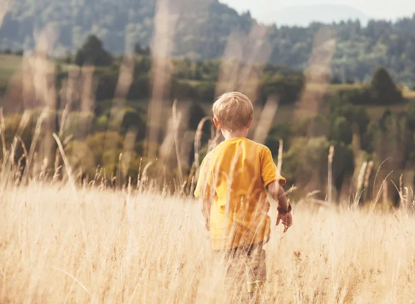 Jongen loopt in gras — Stockfoto