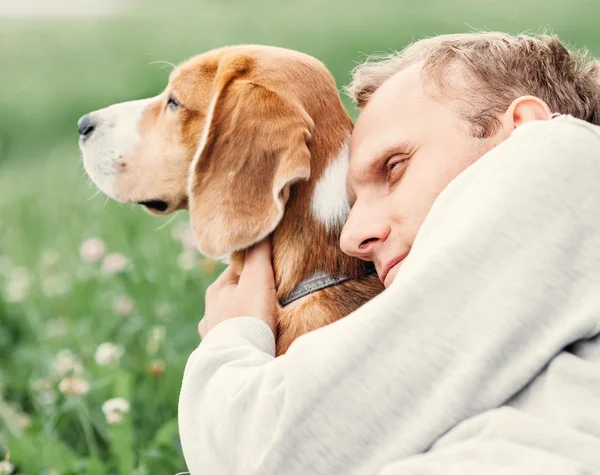 Adam köpeğini hugs — Stok fotoğraf