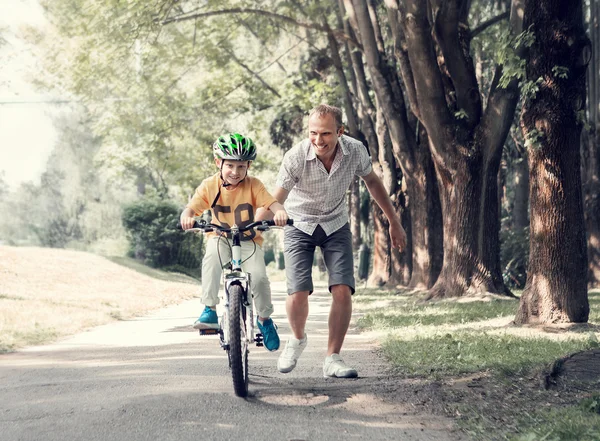 Fiul învață cum să meargă cu bicicleta — Fotografie, imagine de stoc