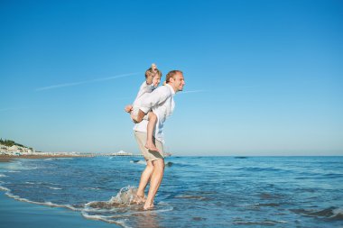 Baba ile oğlu deniz sörf satırındaki