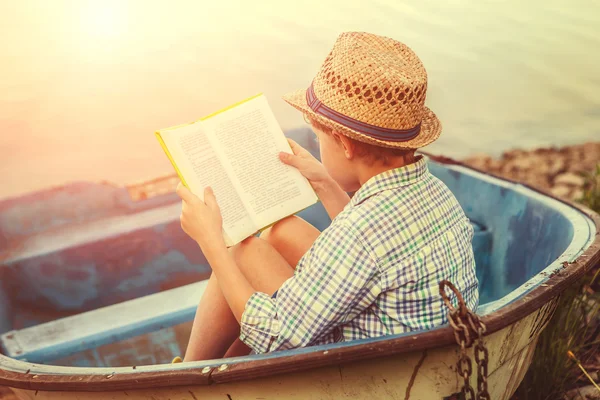 Menino de leitura no velho barco — Fotografia de Stock