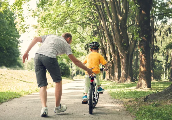 Vader leren zijn zoontje fietsen — Stockfoto