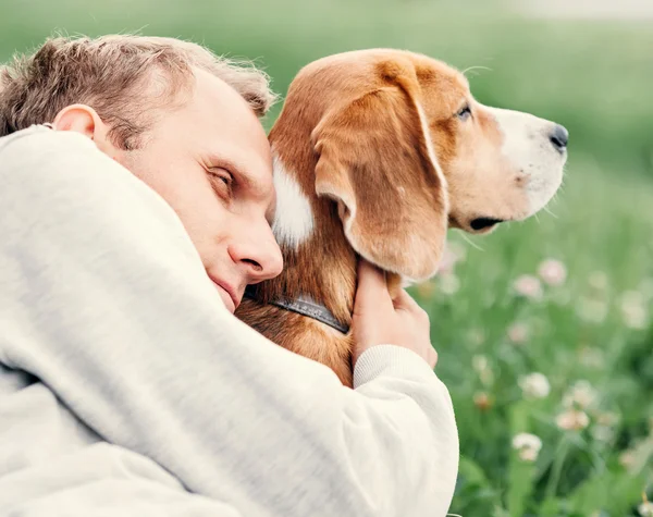 Adam köpeğini hugs — Stok fotoğraf