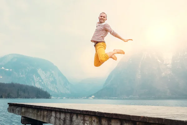 Mann springt auf hölzerne pier — Stockfoto