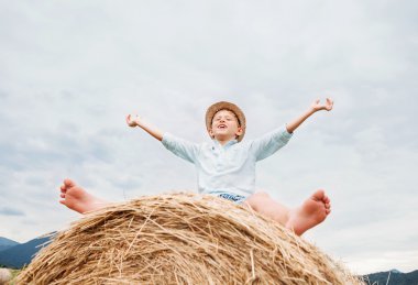 Çocuk haystack üzerinde oturur