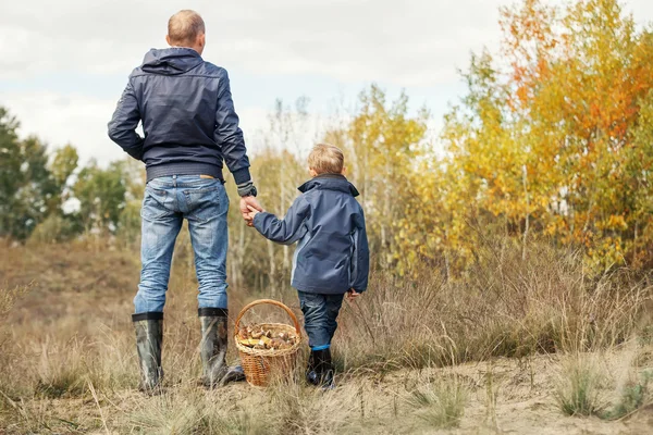 Son och far med full korg med svamp — Stockfoto