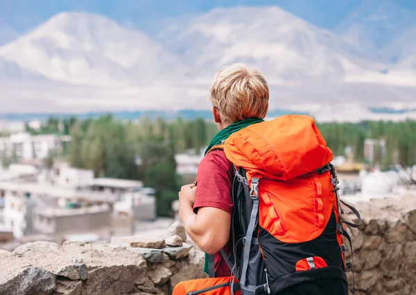 Рюкзак турист дивиться на гори — стокове фото