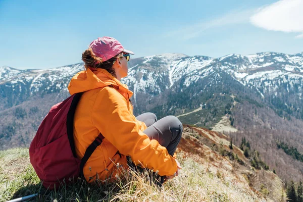 Ubrana Jasnopomarańczowa Kurtka Backpacker Kobieta Siedzi Wzgórzu Ciesząc Się Zieloną — Zdjęcie stockowe