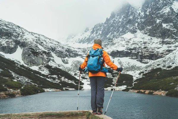 积极的人在自然界的概念 身着鲜艳橙色夹克的女背包客在斯洛伐克塔特拉山高地的Velicka山谷散步 享受着高山湖的美景 — 图库照片