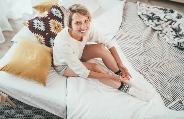 Pijama Giymiş Genç Sarışın Kadın Rahat Bir Yatakta Yastıklarla Oturuyor — Stok fotoğraf