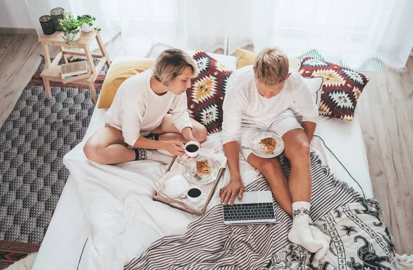 Adolescentes Casal Pijama Cama Acolhedora Navegando Internet Juntos Usando Laptop — Fotografia de Stock