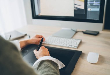 Kadın elleri, resim çizmek için stilus kalem ve modern bilgisayar klavyesiyle grafik tablet kullanıyor. Dünya çapında karantina kavramı üzerine grafik tasarımı, dijital sanatlar veya serbest çalışma