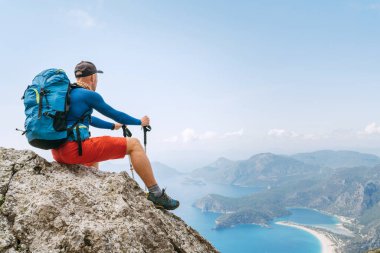 Genç sırt çantalı adam, Lycian Yolu yürüyüşü sırasında Oludeniz 'deki Akdeniz Körfezi' nin tadını çıkarıyor. Meşhur Likya Yolu Türk rotası. Aktif spor insanları tatil konsepti imajı