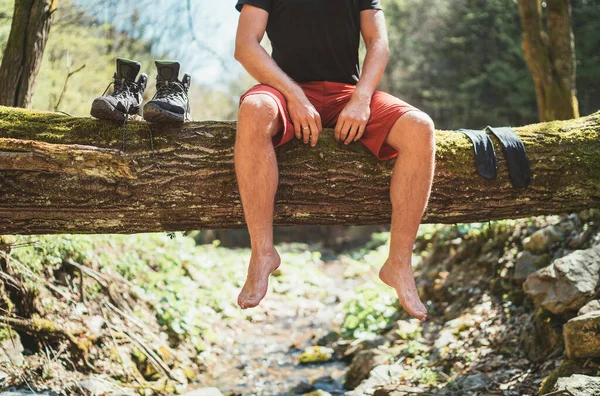 Mann Sitzt Auf Dem Umgestürzten Baumstamm Über Dem Gebirgswaldbach Während — Stockfoto