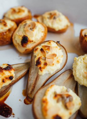 Süzme peynirle doldurulmuş fırında armut ve dilimlenmiş badem fıstığı taze tatlı natürmort fotoğrafı yaptı. Sağlıklı yiyecekler ve düşük kalorili yemek konsepti..