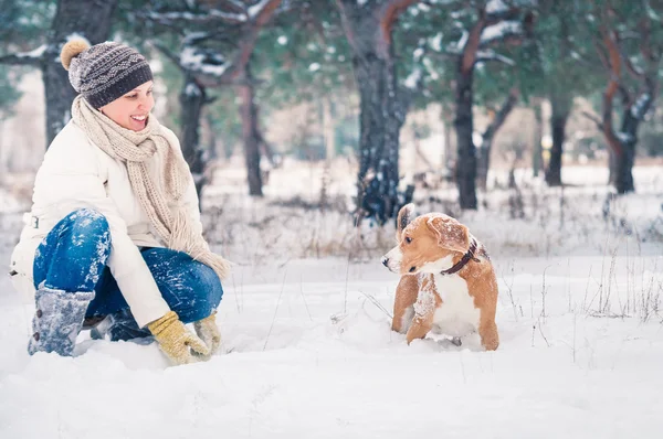 Mujer jugando con su mascota en la nieve —  Fotos de Stock