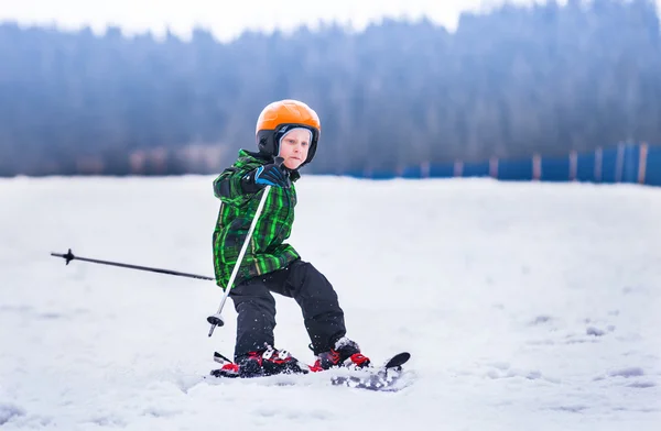 在滑雪板上的小男孩幻灯片。 — 图库照片