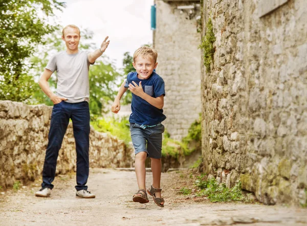 Vater und laufenden Sohn auf der alten Straße — Stockfoto