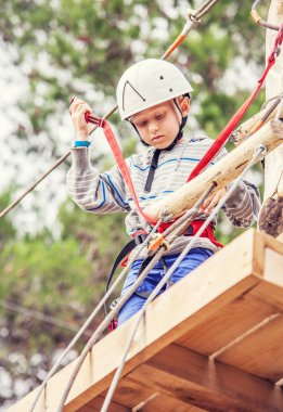 chłopiec na linowy tor przeszkód