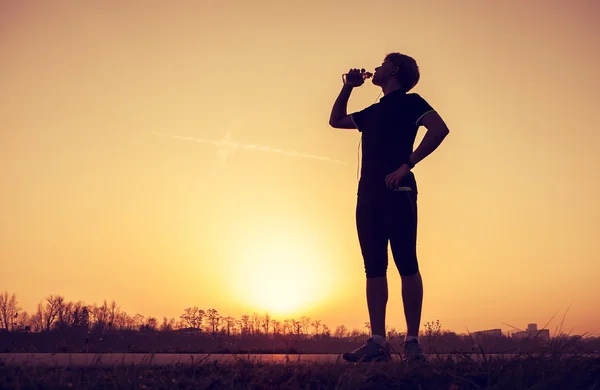 Běžec pije vodu po tréninku — Stock fotografie