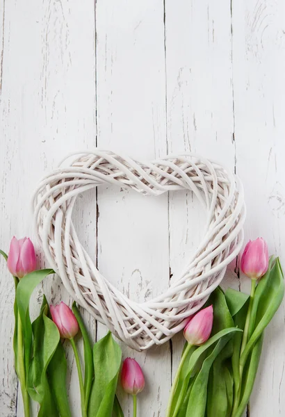 Dřevěné srdce a růžové tulipány — Stock fotografie