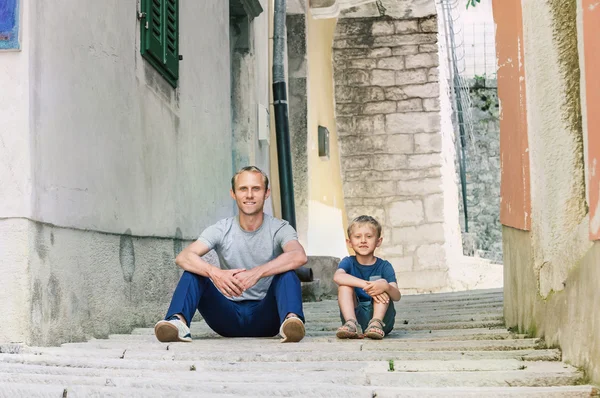 Otec a syn sedí na ulici — Stock fotografie