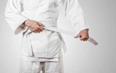 Judoka tying white belt