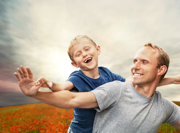 Fils avec le père sur le champ de coquelicots — Photo