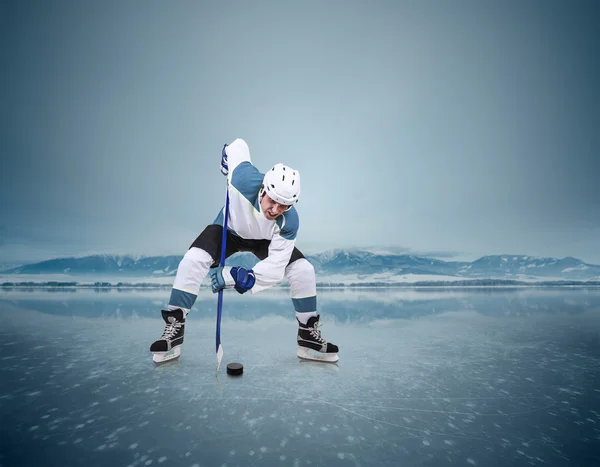 Hockey player on ice lake — Stock Photo, Image