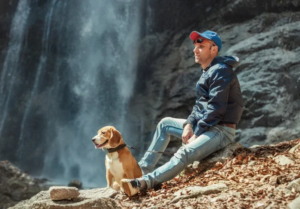 Man med hund nära vattenfallet — Stockfoto