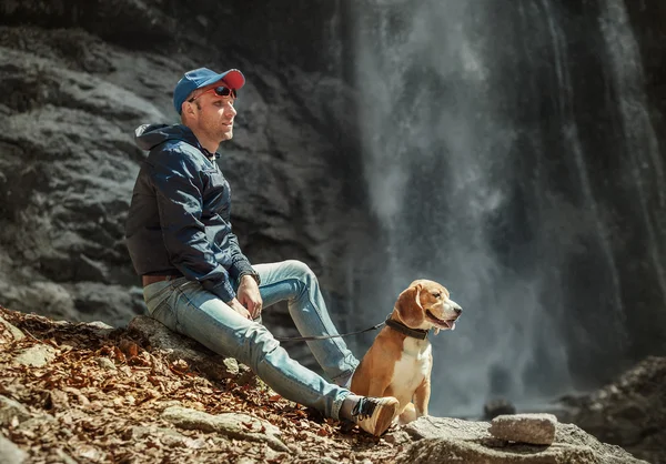 Man med hund nära vattenfallet — Stockfoto