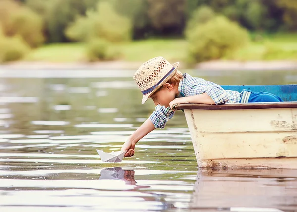 Pequeno menino lançamento papel navio — Fotografia de Stock