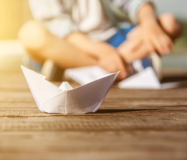 Muchacho con barco de papel en muelle — Foto de Stock