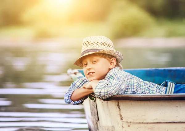 Dreaming boy lying in old boat — Stock Photo, Image