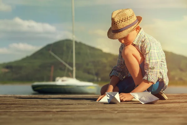 Petit garçon faire des bateaux en papier — Photo