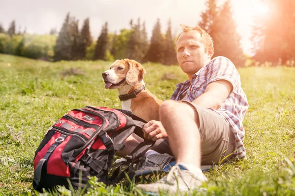 Человек с собакой на горном холме — стоковое фото