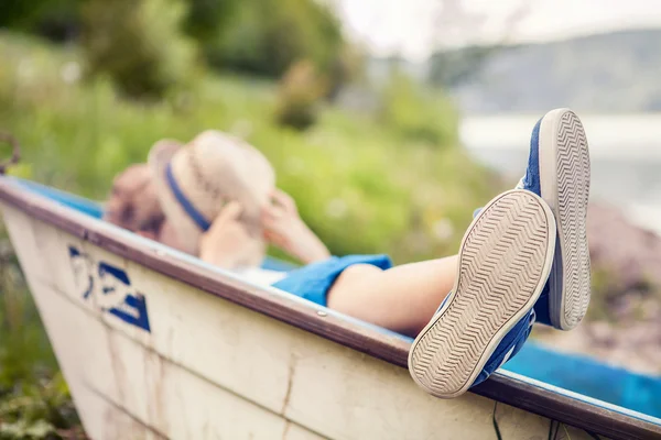 Pojken låg i gamla båt — Stockfoto