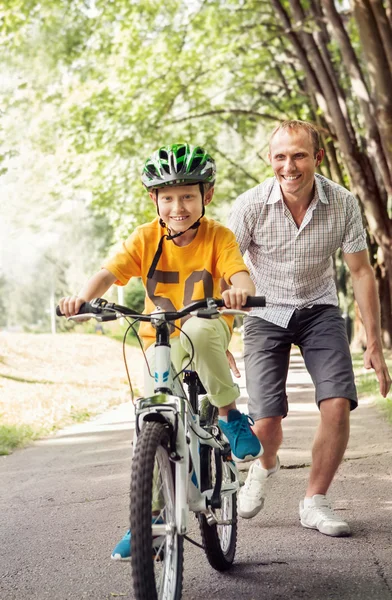 Menino aprender a andar de bicicleta com o pai — Fotografia de Stock