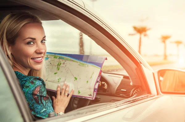 Femme assise dans la voiture avec la carte aroads — Photo