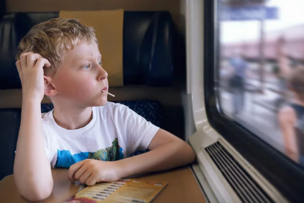 Garçon avec le regard de bonbons en train — Photo