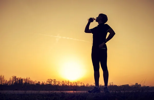 Běžec pije vodu po tréninku — Stock fotografie