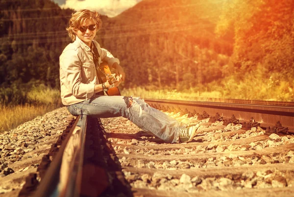 Hombre con la guitarra sentado en el tren — Foto de Stock