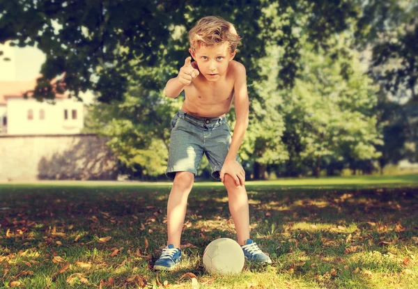 Menino no parque pronto para chutar a bola — Fotografia de Stock