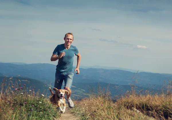 Uomo che corre con il suo cane — Foto Stock