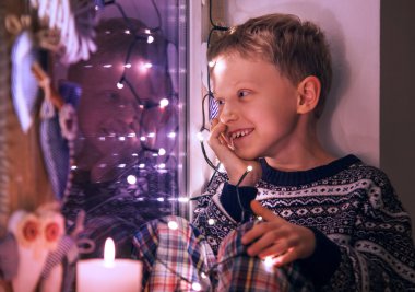 Çocuk Noel ışıkları penceresindeki