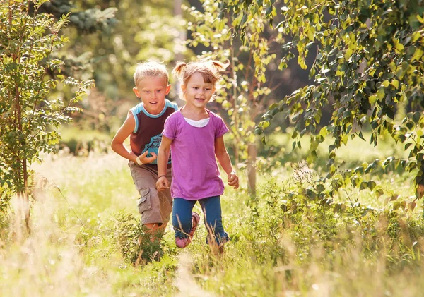 Kis lány és fiú nyári kert — Stock Fotó
