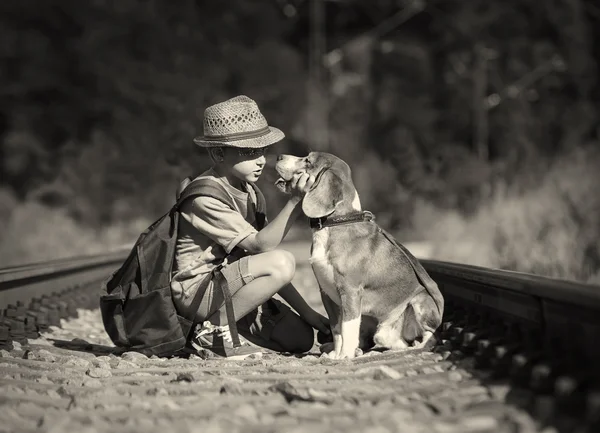 Jongen en hond zittend op de spoorlijn — Stockfoto