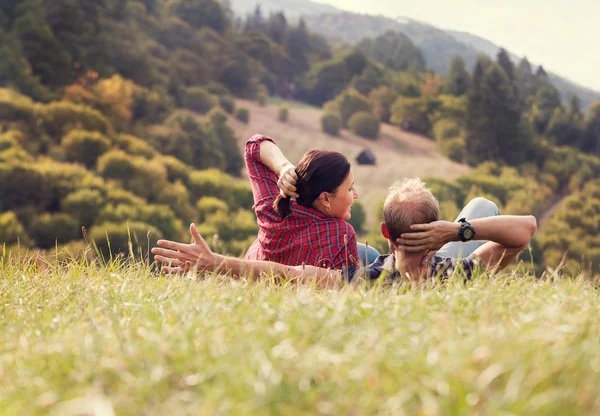 Couple lying in green grass — Stock Photo, Image