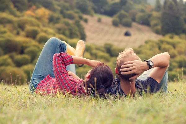 Пара отдых в зеленой траве на холме — стоковое фото