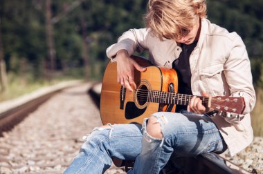 adam gitar demiryolu üzerinde oynamak